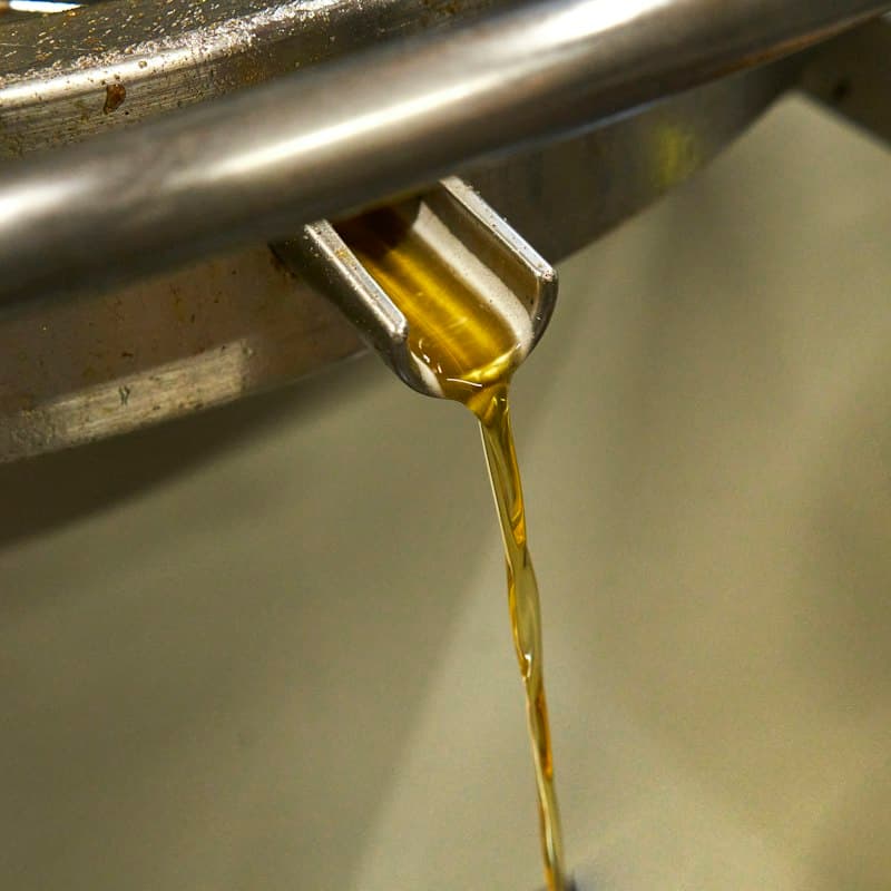 Amber liquid being poured from a steel tap