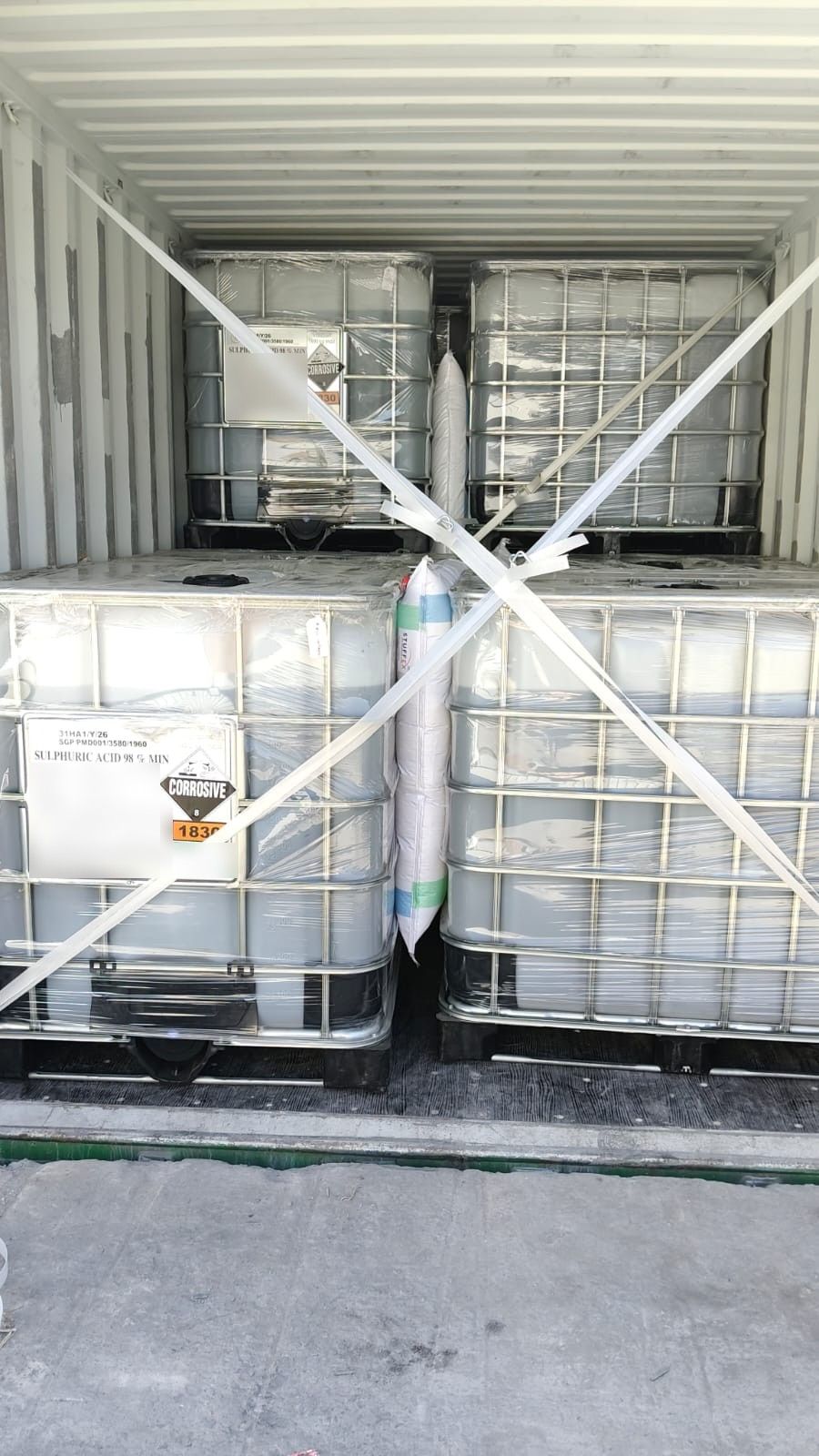 Four IBCs of sulphuric acid 98% stacked two high in a container, cross-strapped with a dunnage airbag between them